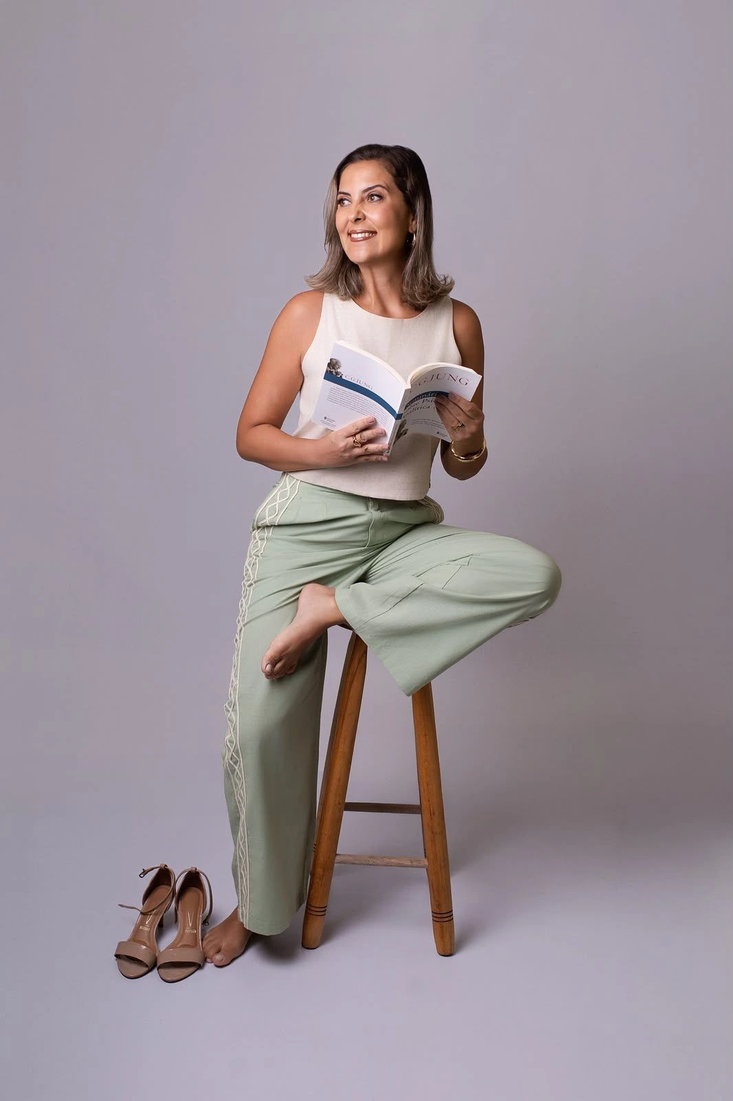 Lianne Silva Santos sentada, segurando um livro de Carl Jung